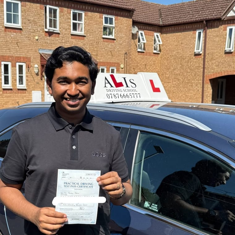 A pupil holding their practical driving test pass certificate beside Ali's car in King's Lynn.